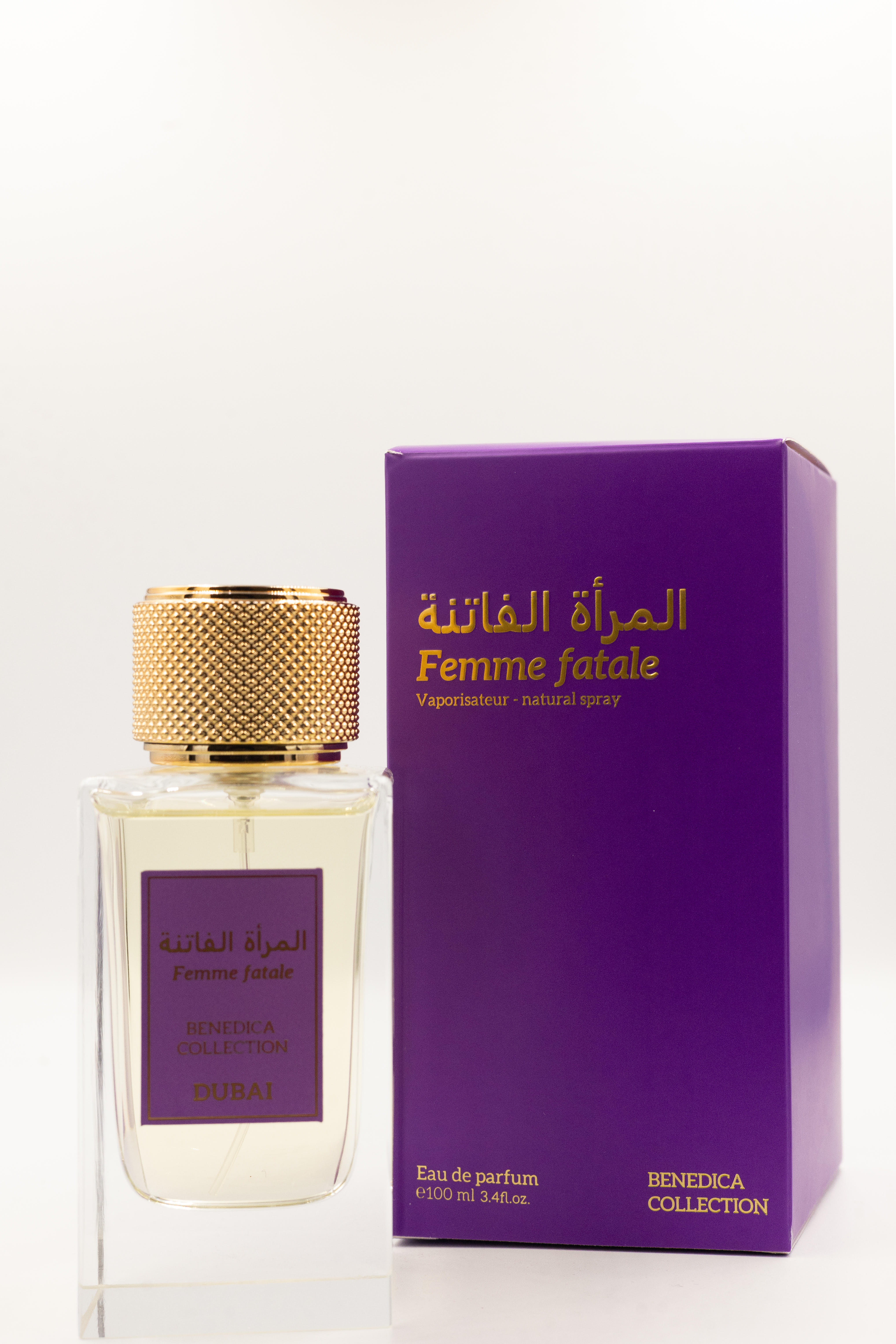 A clear glass BENEDICA FEMME FATALE EDP bottle with a gold textured cap stands next to a purple box, both labeled in English and Arabic with Dubai and Benedica Collection, suggesting a fruity-floral scent with damask rose notes.
