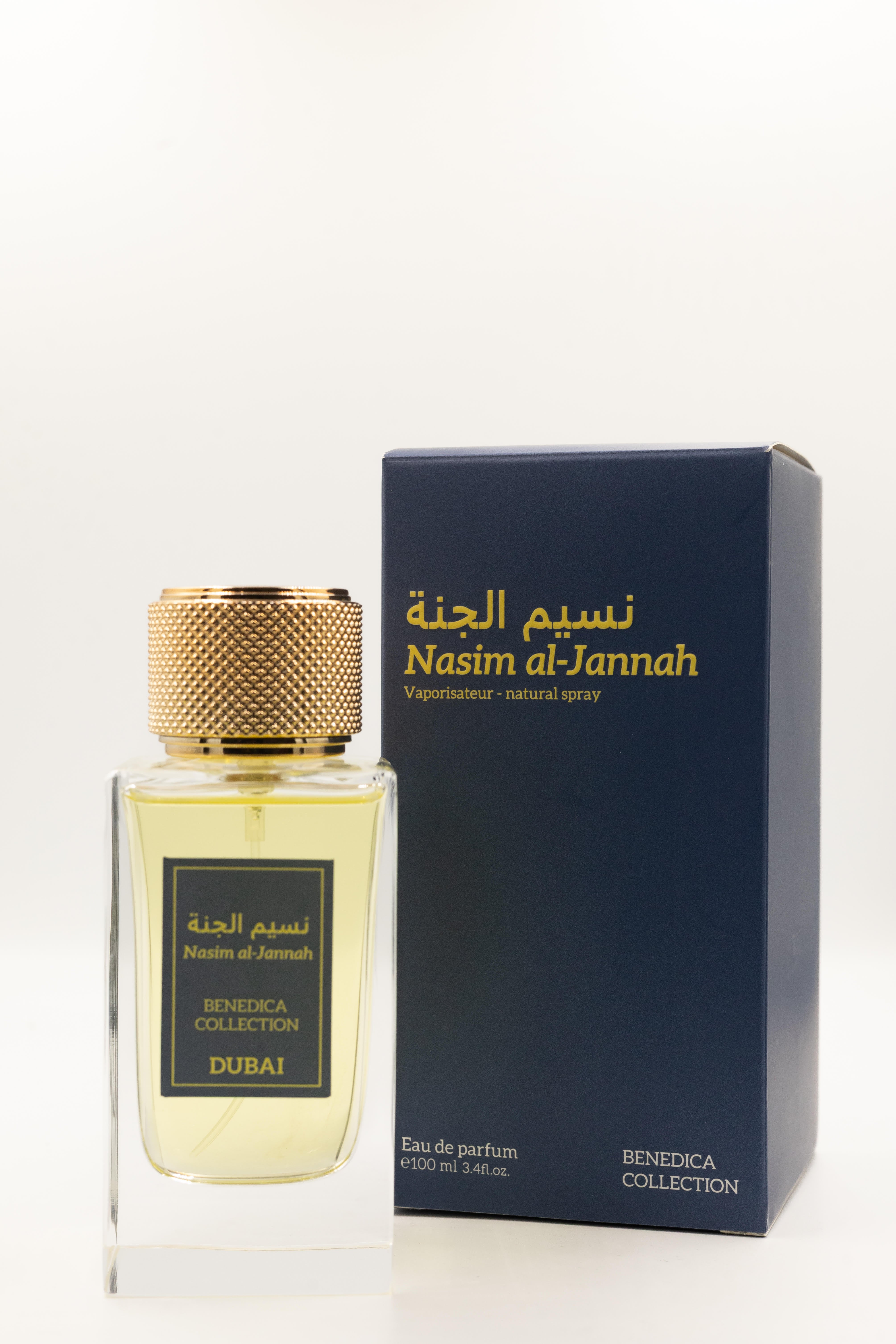 A clear glass bottle labeled BENEDICA NASIM AL JANNAH EDP UNISEX stands beside a navy blue box with gold text, both featuring the BENEDICA COLLECTION branding and embodying unisex elegance.
