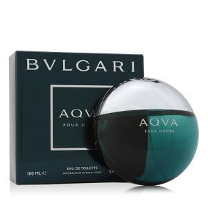 A round teal and silver bottle of BVLGARI AQUA POUR HOMME EDT MAN by Self sits beside its matching dark teal box, featuring bold BVLGARI AQVA branding and an aquatic, citrus-infused fragrance.