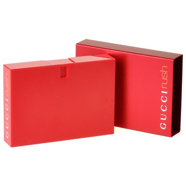 A red rectangular bottle of GUCCI RUSH EDT WOMEN stands beside its matching box, both showing the GUCCI brand name, highlighting this iconic womens fragrance known for its floral and fruity notes.