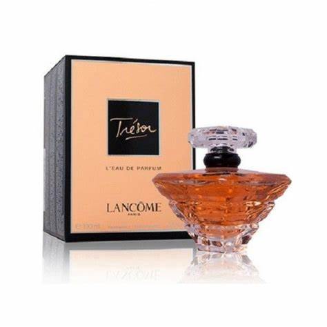 A bottle of LANCOME TRESOR EDP WOMEN stands before its peach and black box with gold lettering. The faceted bottle, from the brand LANCOME, holds an amber floral oriental fragrance.