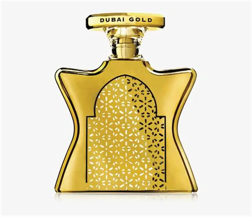 Gold perfume bottle with intricate design and 'Dubai Gold' text on a white background